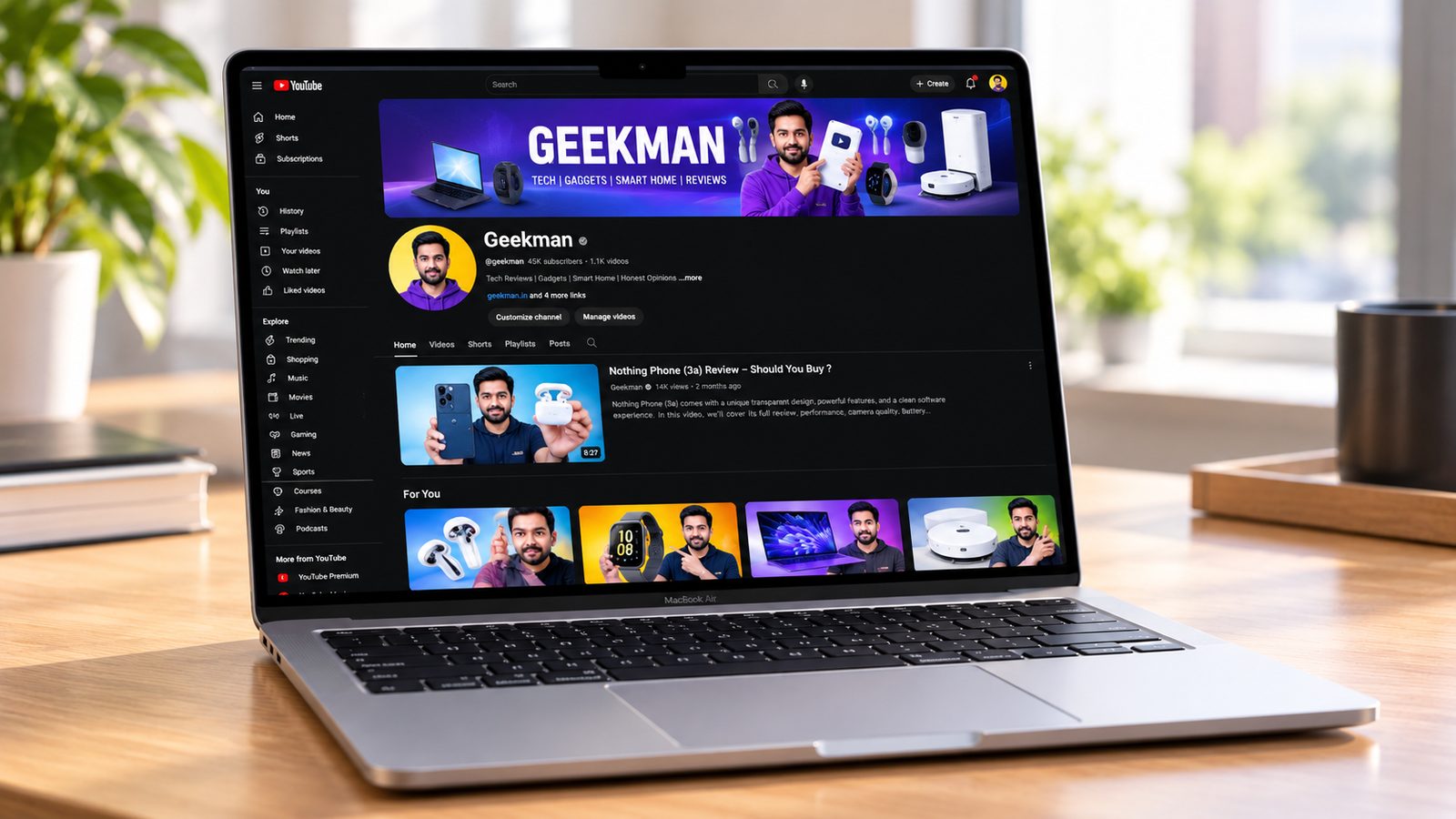 Apple MacBook Air 13.6 inch M5 laptop with Geekman YouTube channel banner on screen