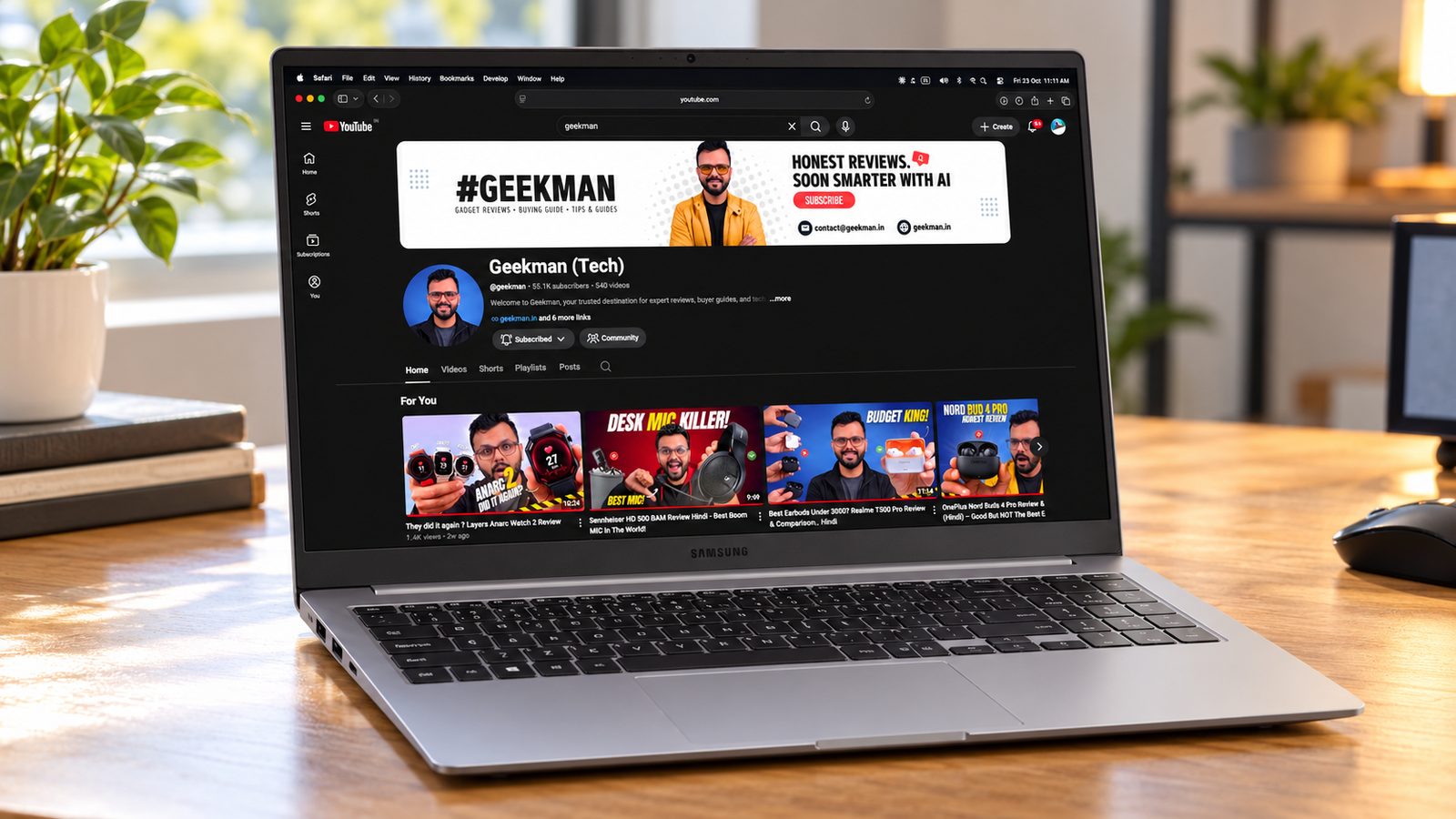 Samsung Galaxy Book5 AI Metal laptop on a wooden desk with the Geekman channel on screen