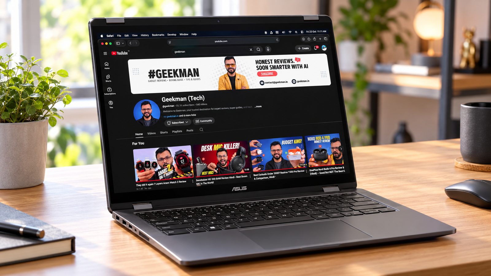 ASUS Vivobook 14 Flip OLED laptop on a wooden desk with the Geekman channel on screen