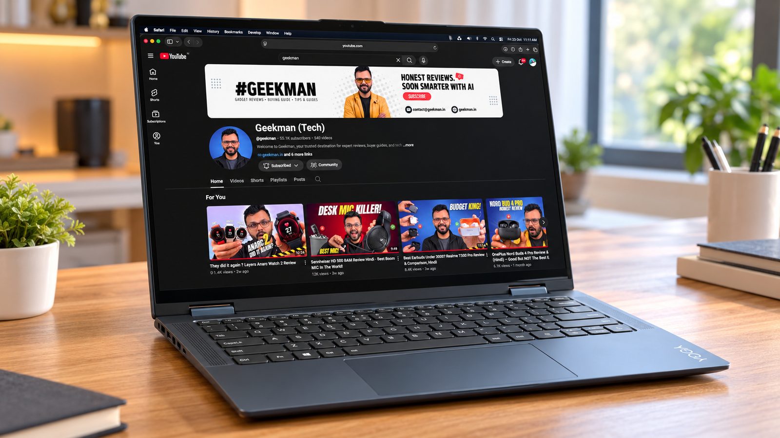 Lenovo Yoga 7 2-in-1 OLED laptop on a wooden desk with the Geekman channel on screen