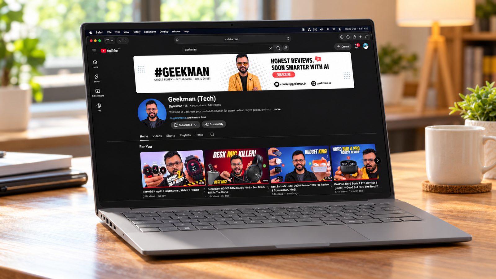ASUS Zenbook A14 OLED laptop on a wooden desk with the Geekman channel on screen